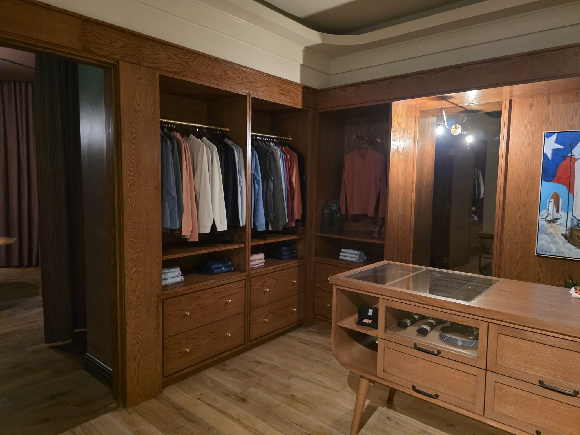 Custom stained oak walk-in closet system with glass-top display island and drawers in Winston-Salem NC