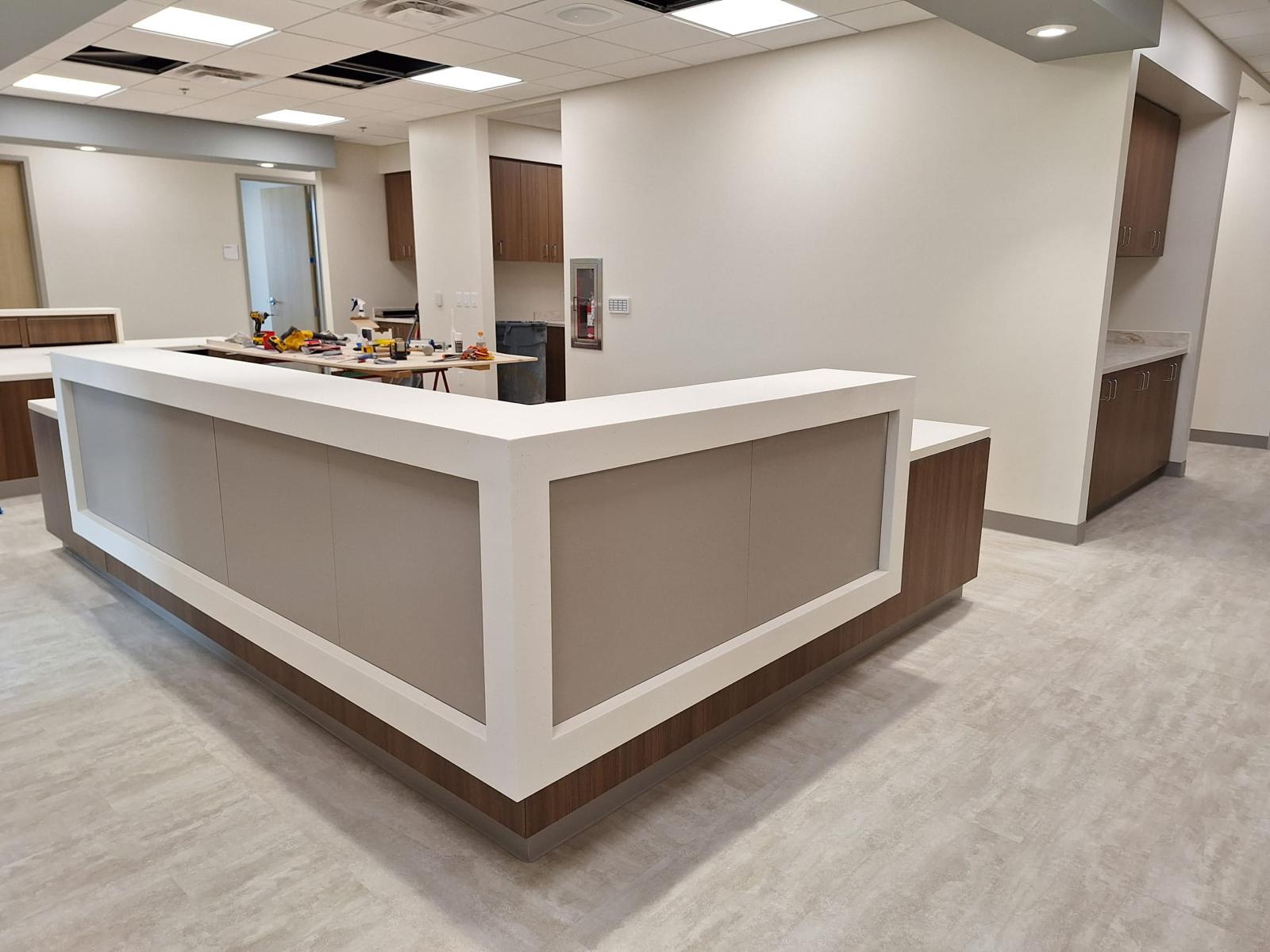 Modern white and wood wrap reception station desk installed in commercial office Clemmons NC