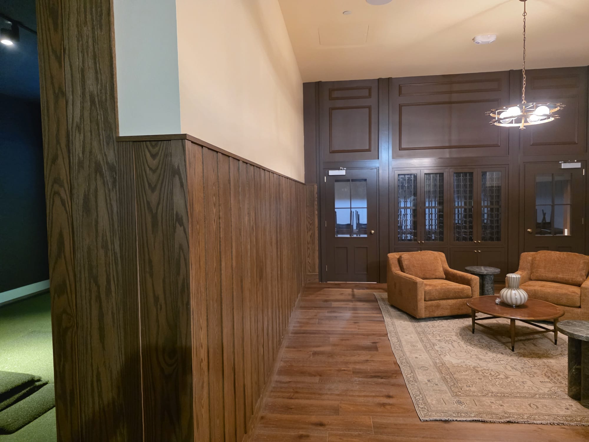 Executive lounge with vertical oak wainscoting paneling, dark wood cabinetry and coffered entry door in Winston-Salem NC