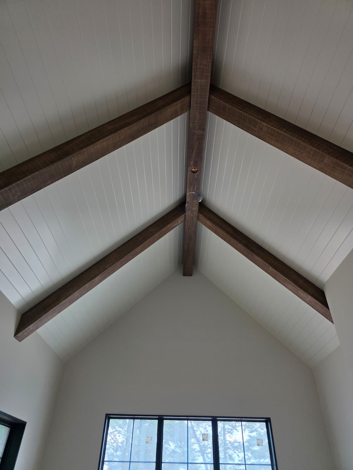 Vaulted cathedral ceiling with dark walnut stained wood beams and white tongue-and-groove shiplap in Clemmons NC