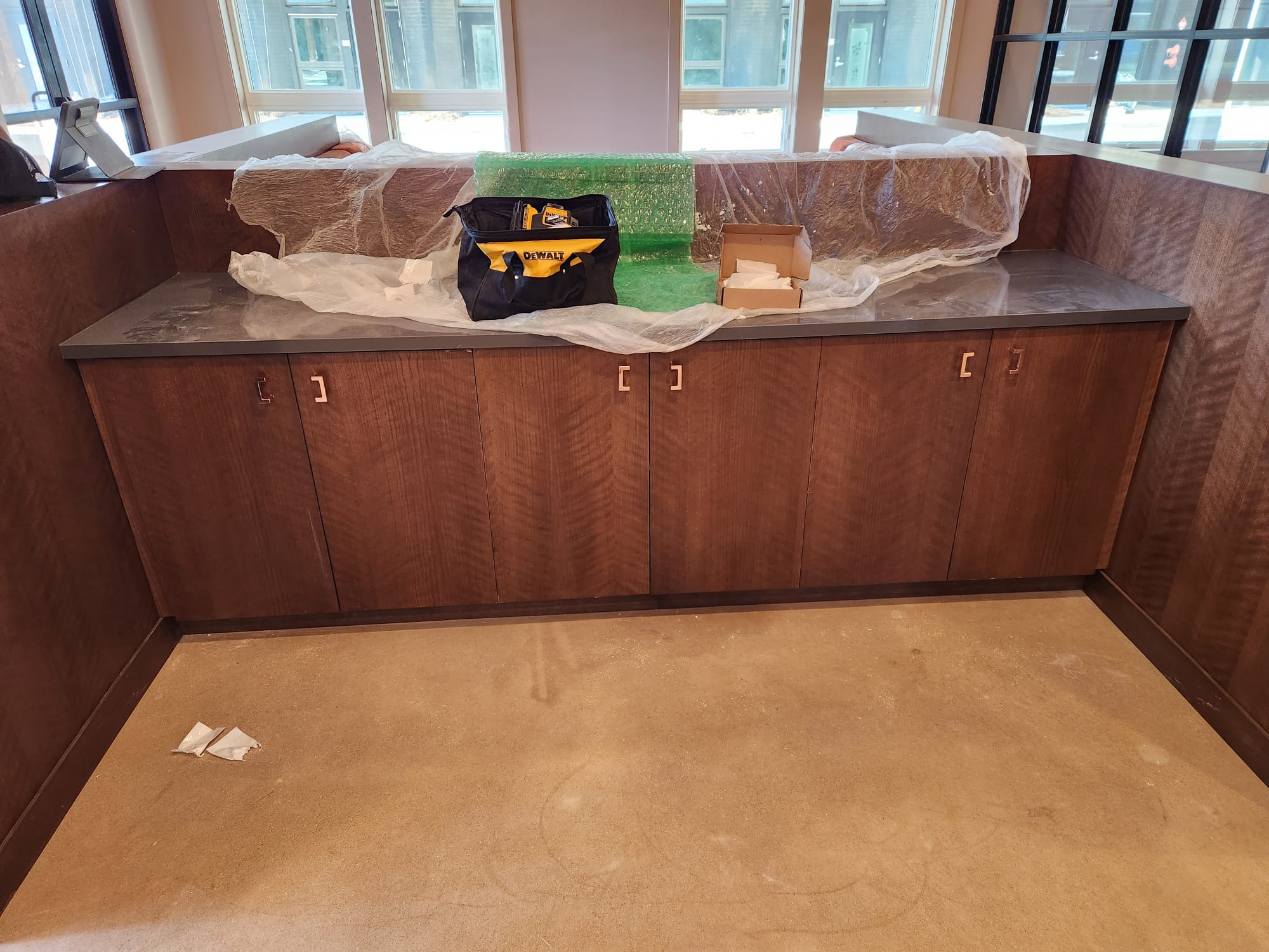 Commercial reception credenza with vertical wood veneer doors and stone countertop in Clemmons NC