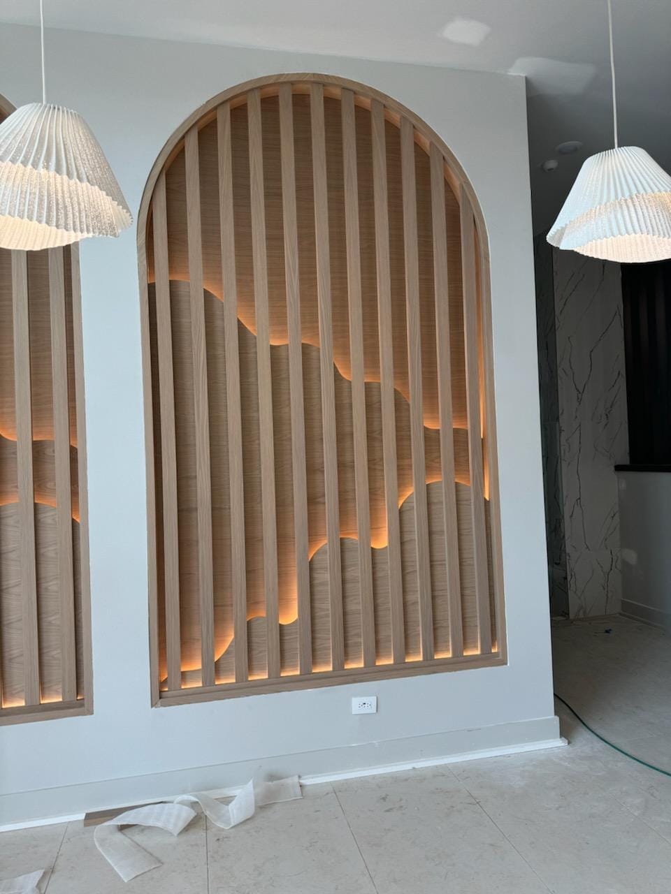 Arched timber slat architectural feature wall with warm integrated backlighting in Greensboro NC