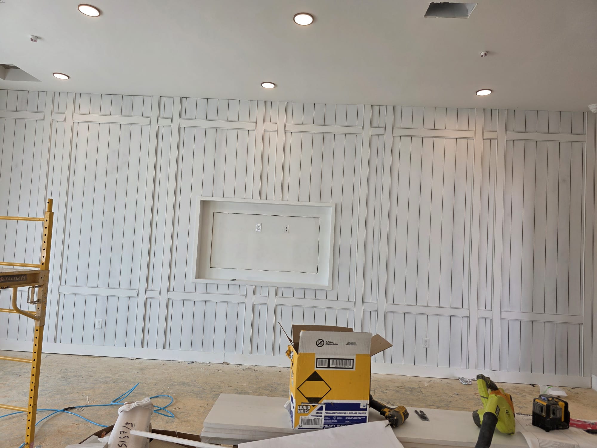 Custom full-height white board and batten geometric wall with recessed media niche in Greensboro NC