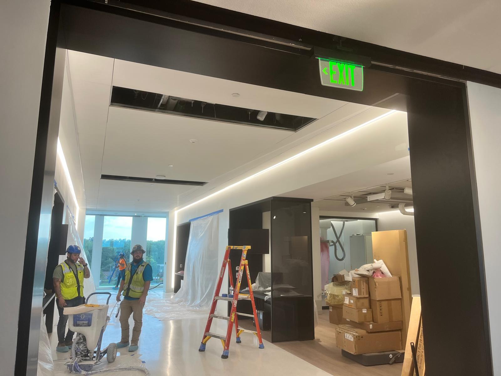 Commercial finish carpentry team installing architectural portal framing and ceiling cove lighting in Winston-Salem NC