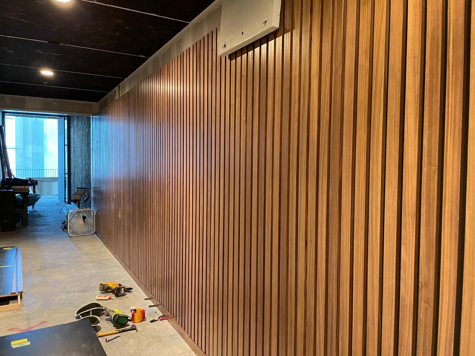 Vertical oak timber slat architectural accent wall in hallway installed by Crafted Wood & Trim