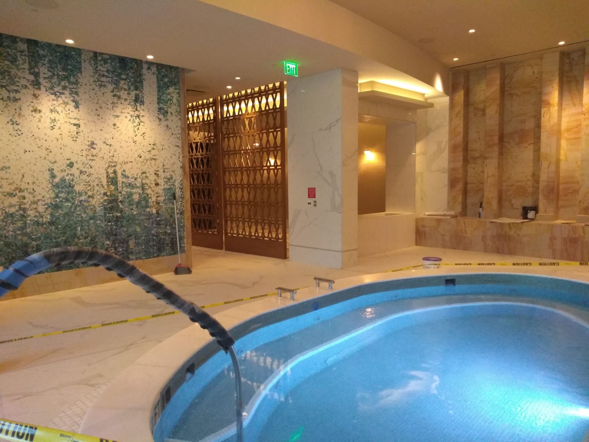 Custom geometric fretwork wood screens and cove lighting in luxury wellness facility in Greensboro NC