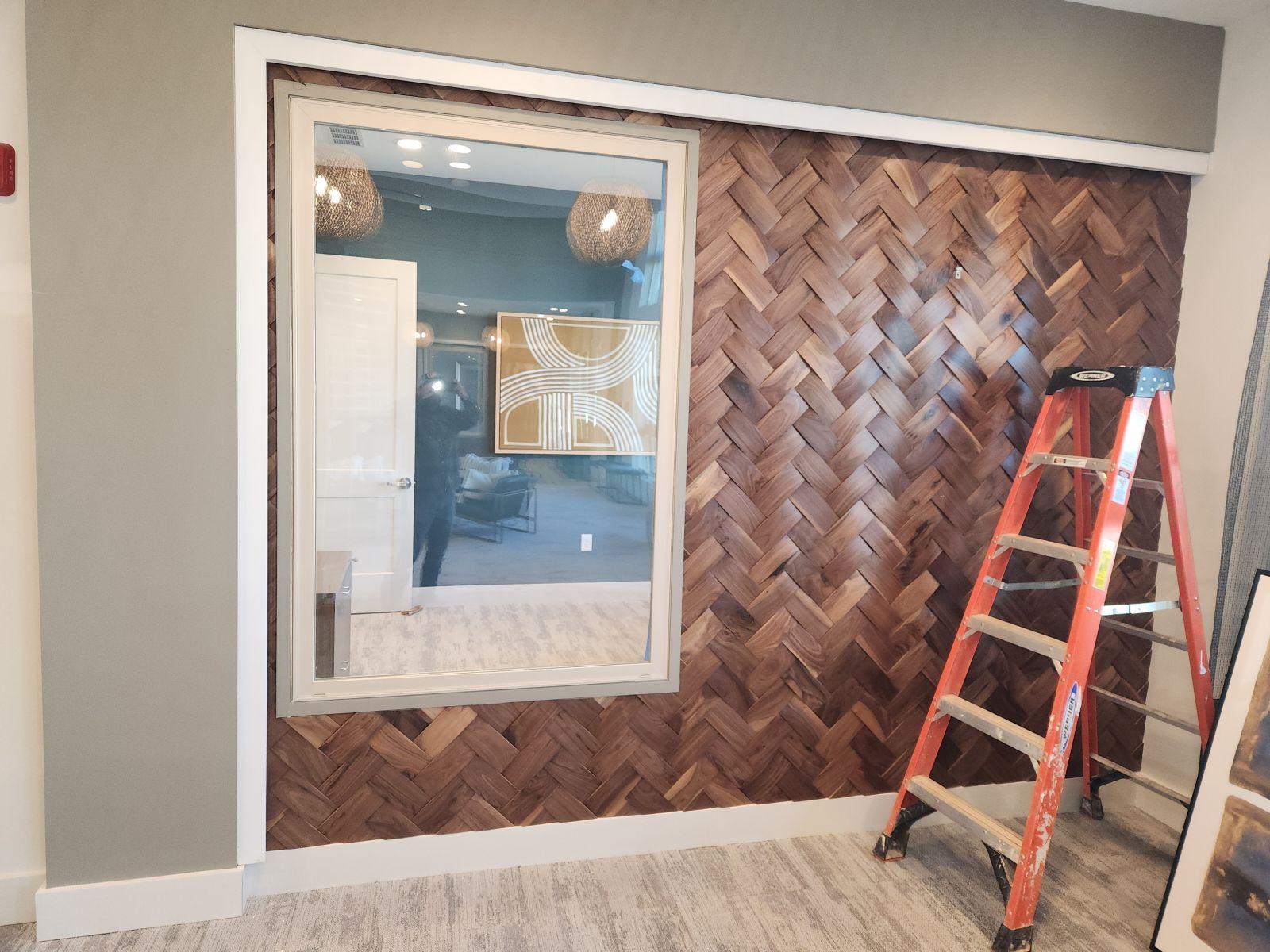Woven herringbone dimensional wood wall cladding feature around interior office window completed in Clemmons NC