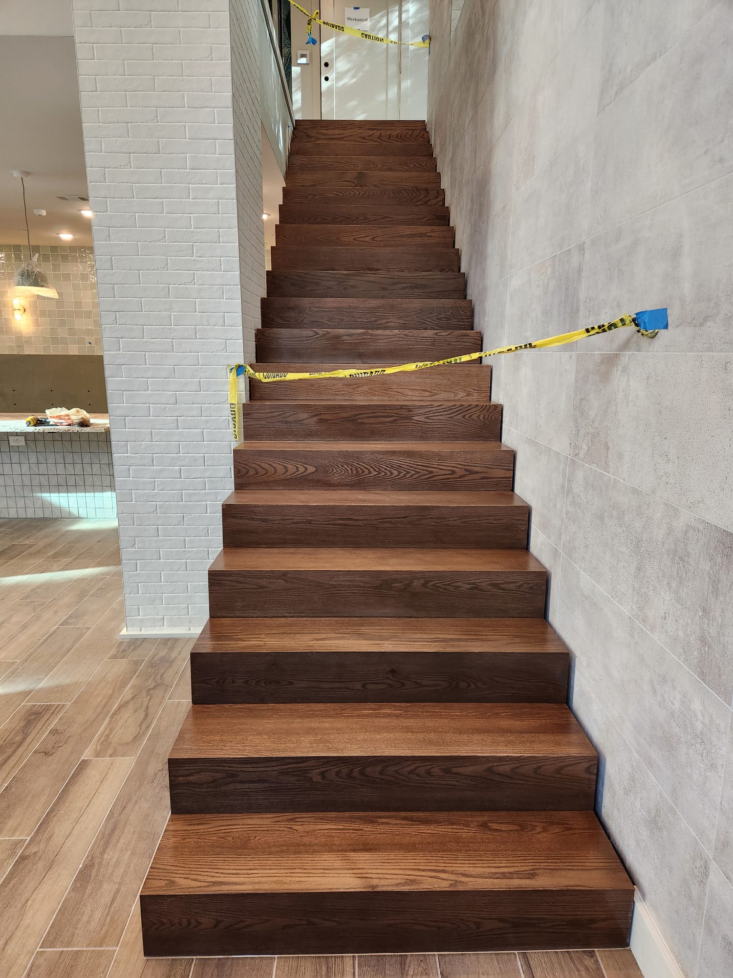 Custom solid dark stained oak staircase treads and risers installed by Crafted Wood & Trim in Winston-Salem NC