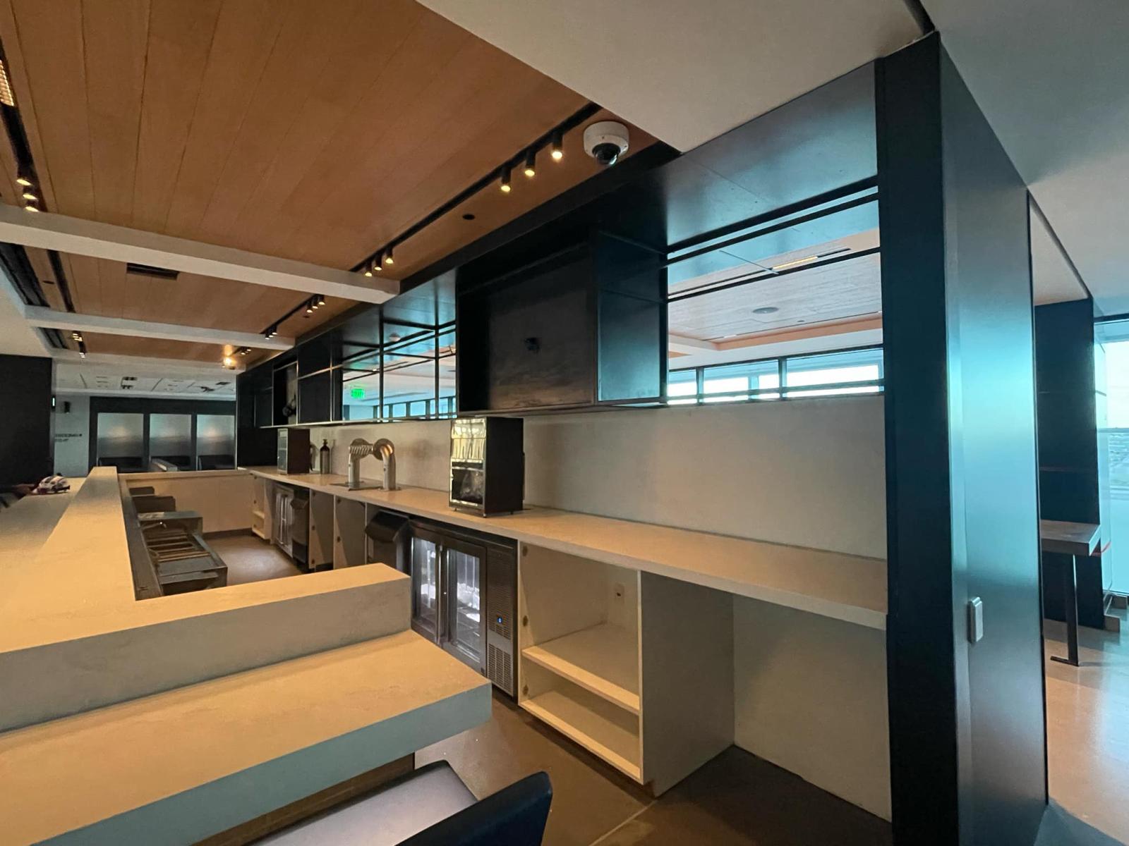 Warm wood plank tongue-and-groove ceiling with custom commercial bar millwork and track lighting
