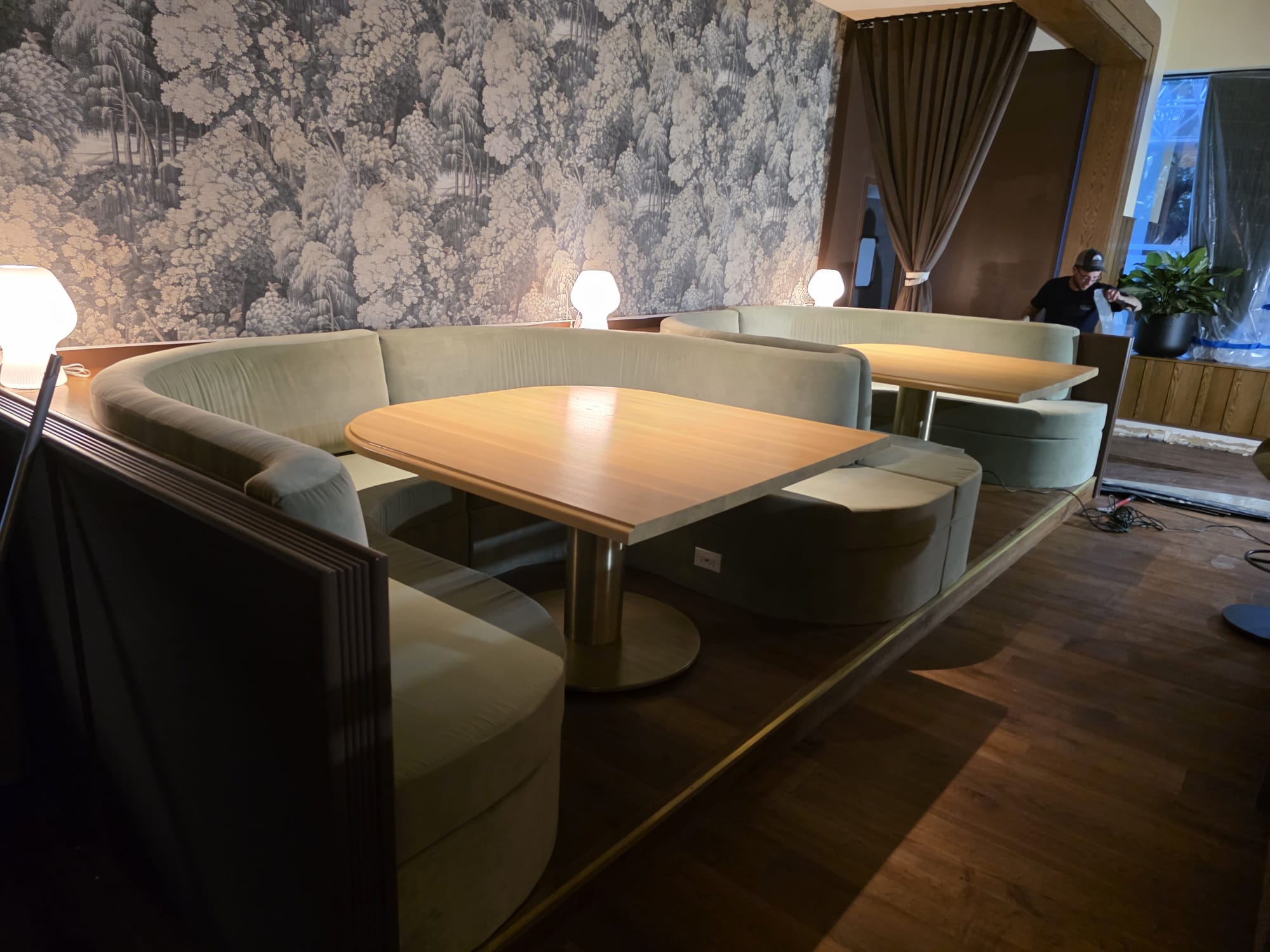 Custom curved upholstered booth seating with solid wood tables and paneled partition trim in Clemmons NC