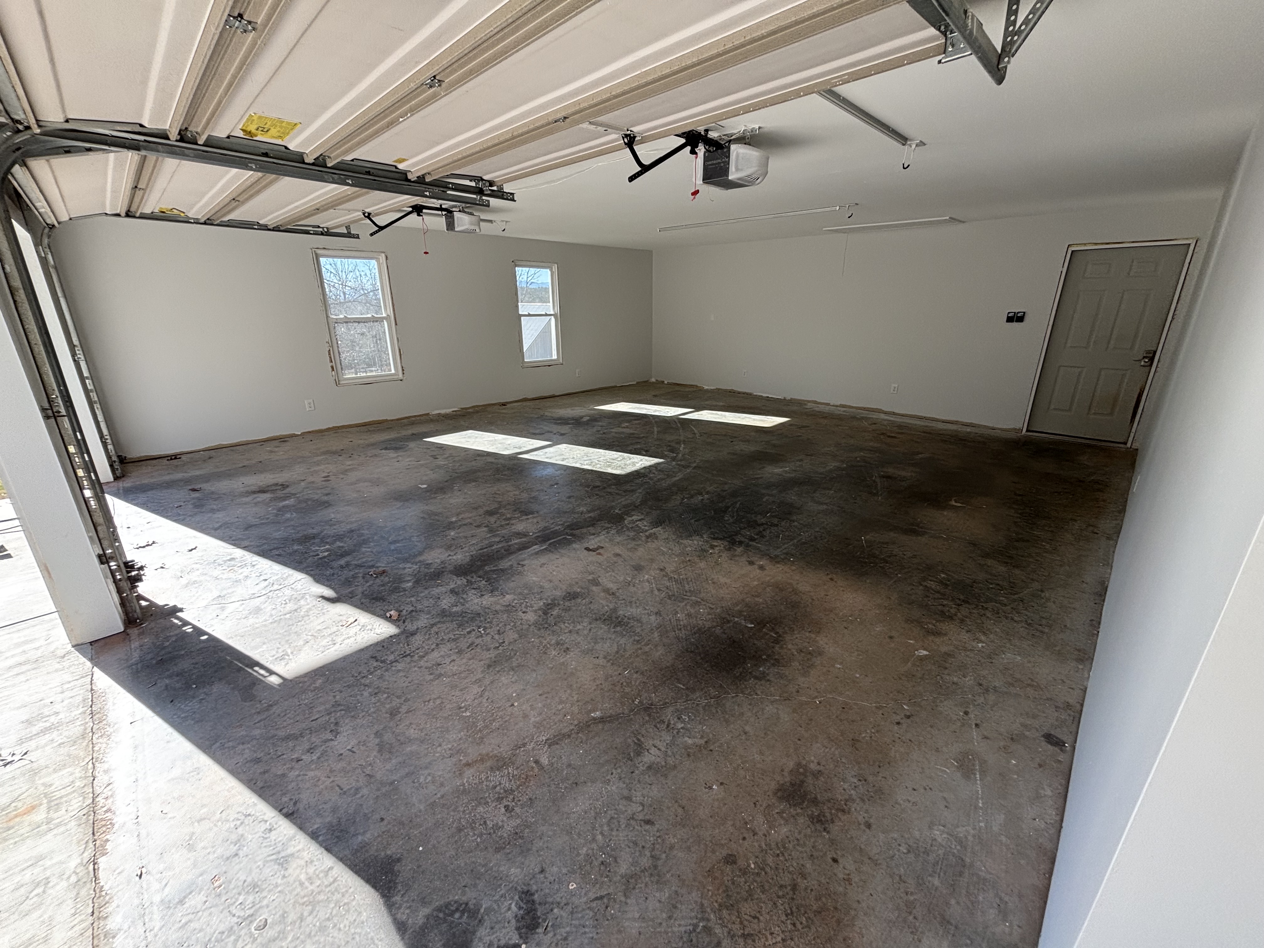 Raw unfinished concrete garage floor with tire marks and stains before ONYX installation