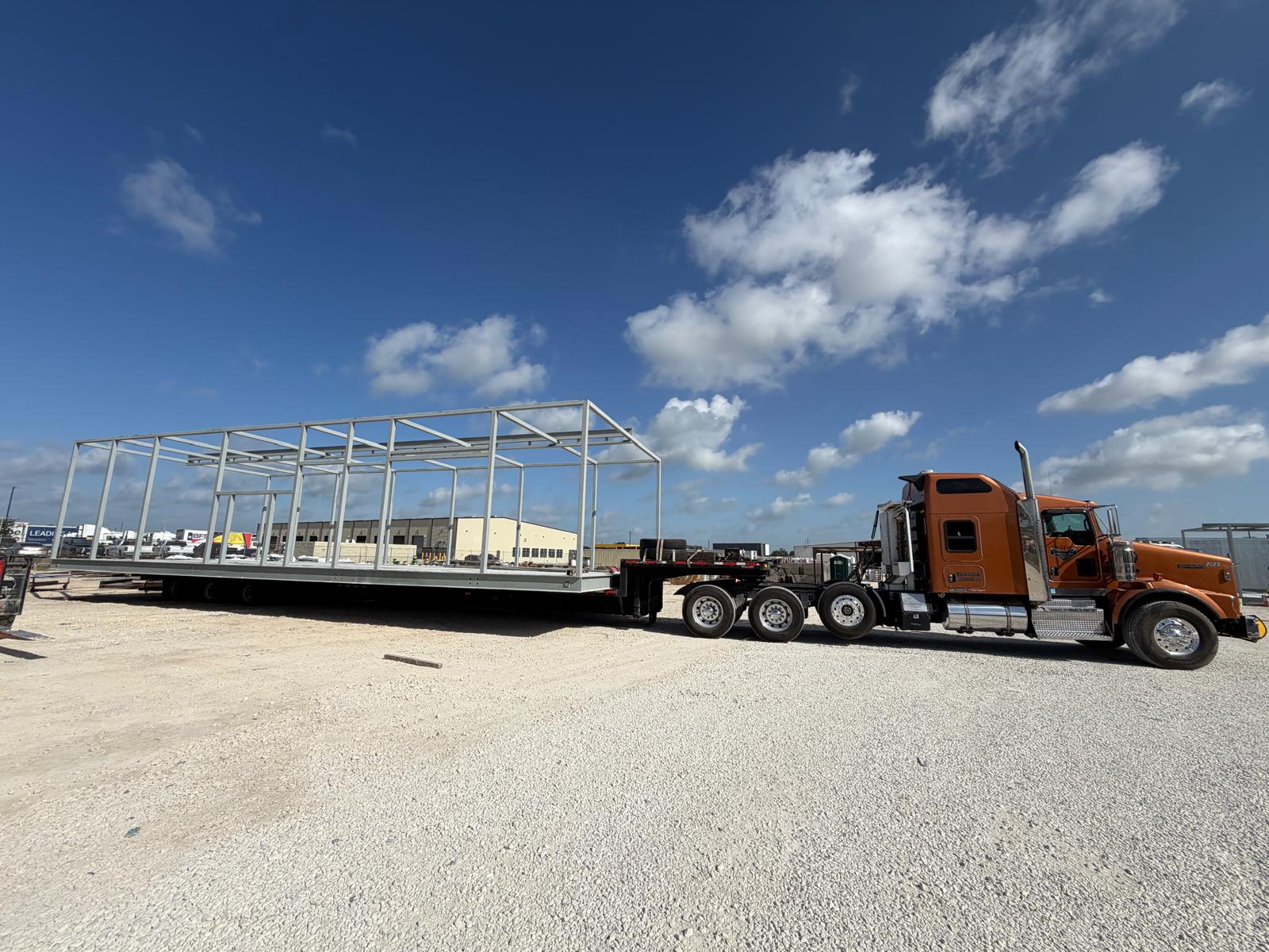 Heavy haul truck transporting long steel structural framework on multi-axle stretch trailer