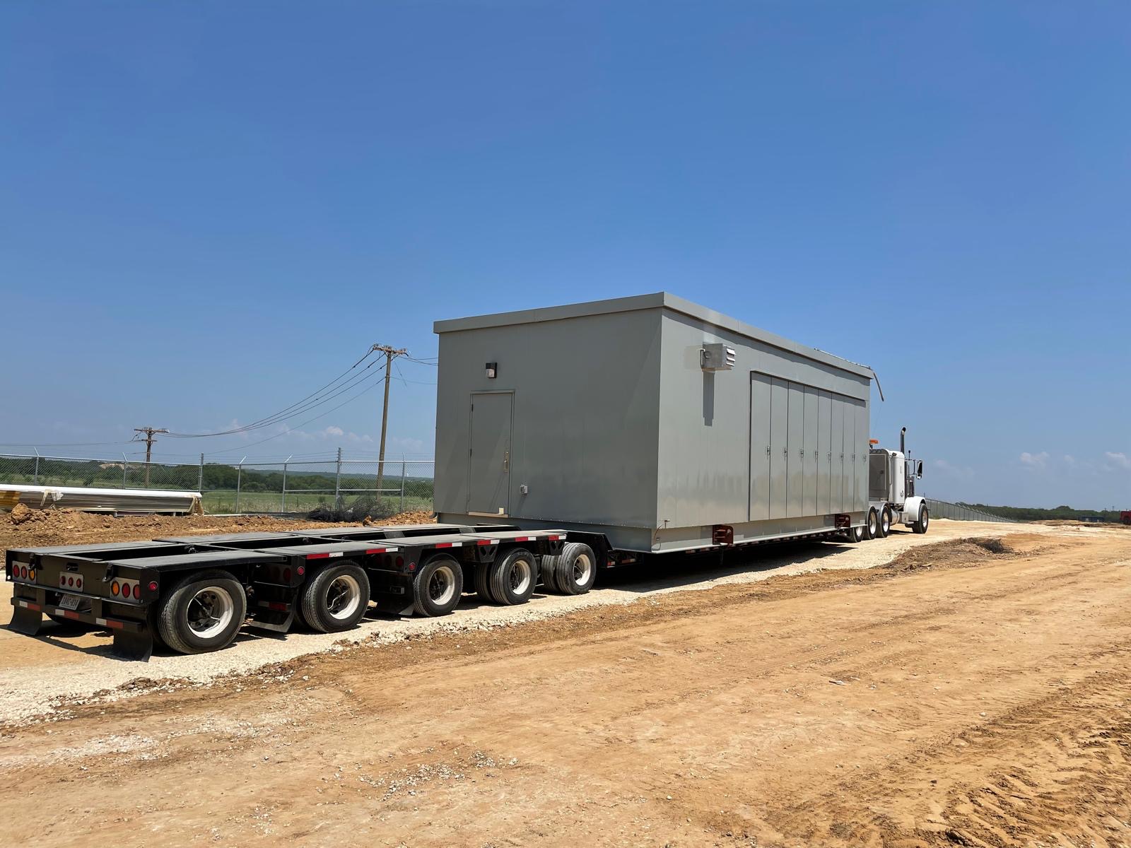 Prefabricated electrical control house building transport on multi-axle lowboy