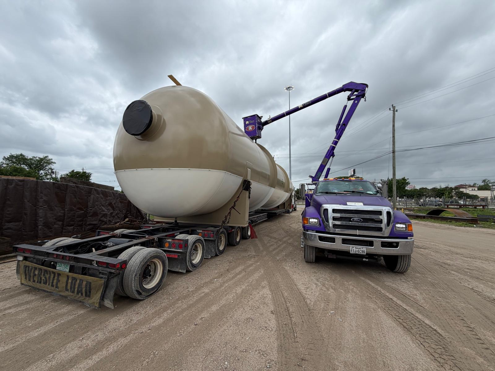 Oversized industrial vessel transport with bucket truck lifting utility lines