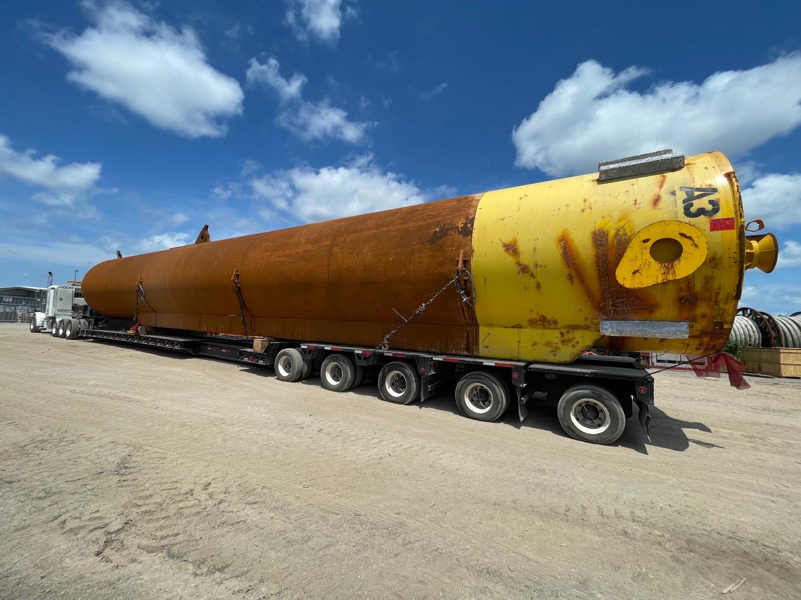 Massive industrial pressure vessel column secured on extended multi-axle heavy transport