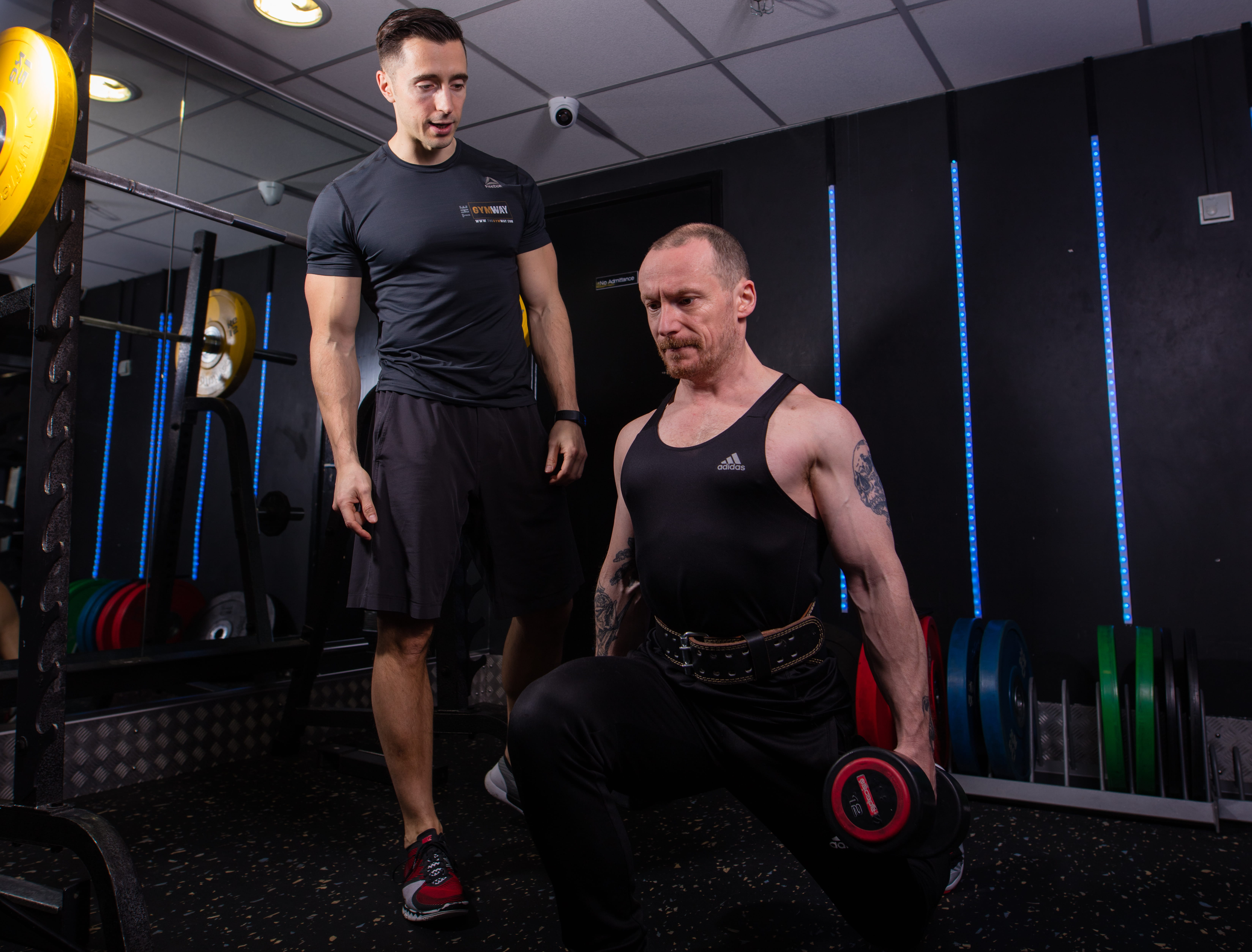 Fabio Bonanno actively coaching a client during dumbbell lunges in the gym