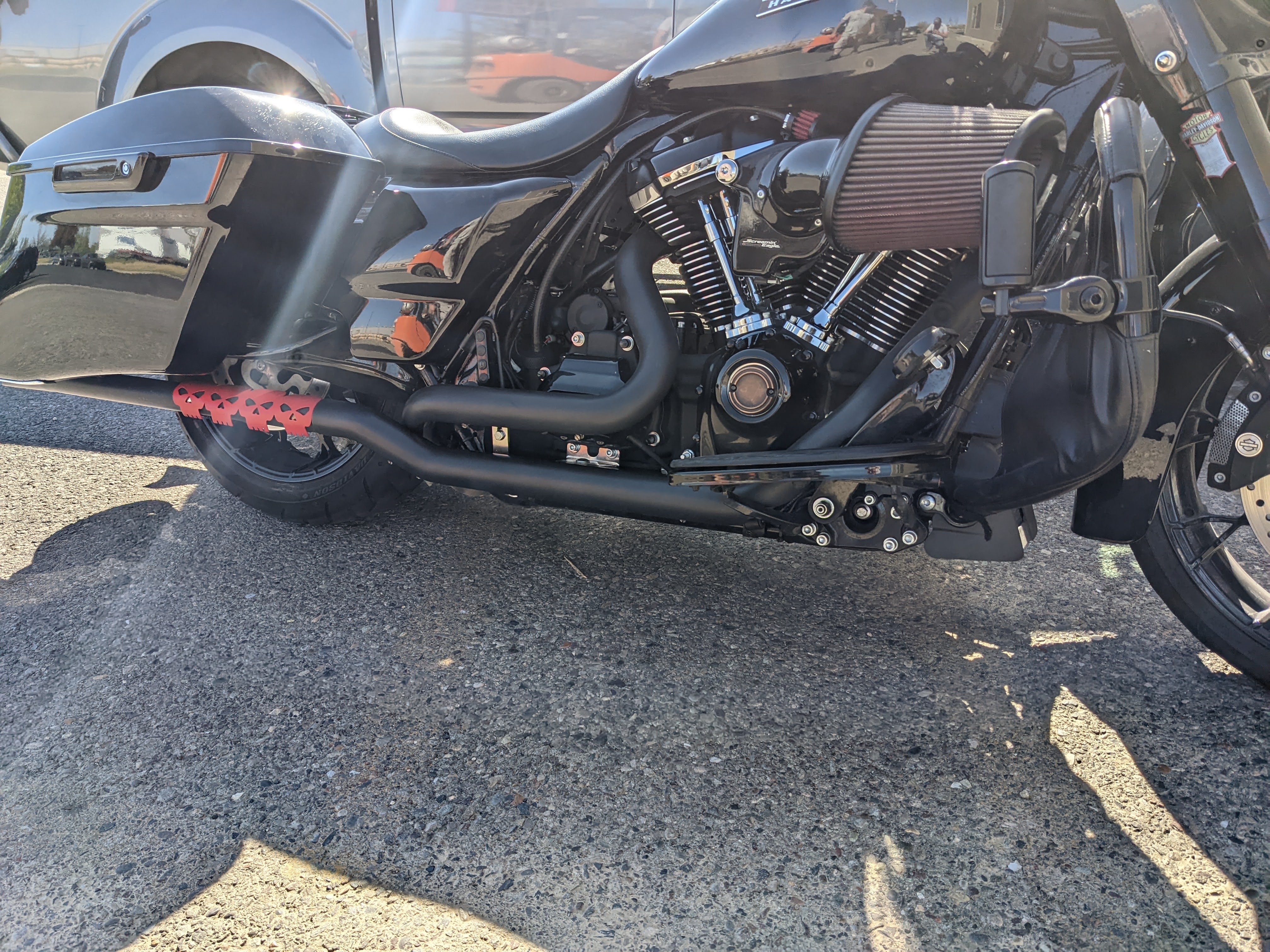Custom black exhaust and skull accent finish on Harley-Davidson motorcycle