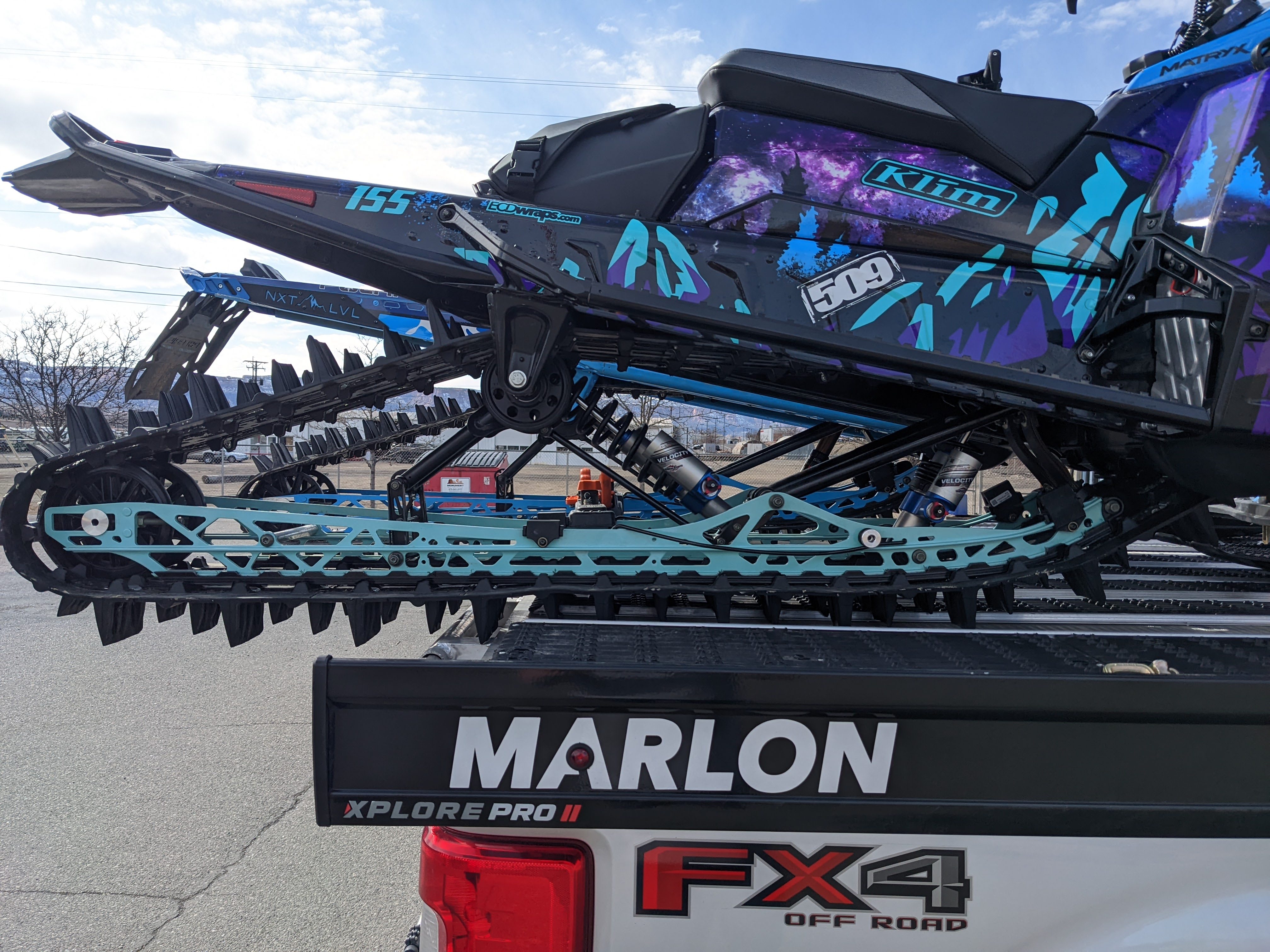 High-performance snowmobile suspension rails powder coated in custom turquoise cyan
