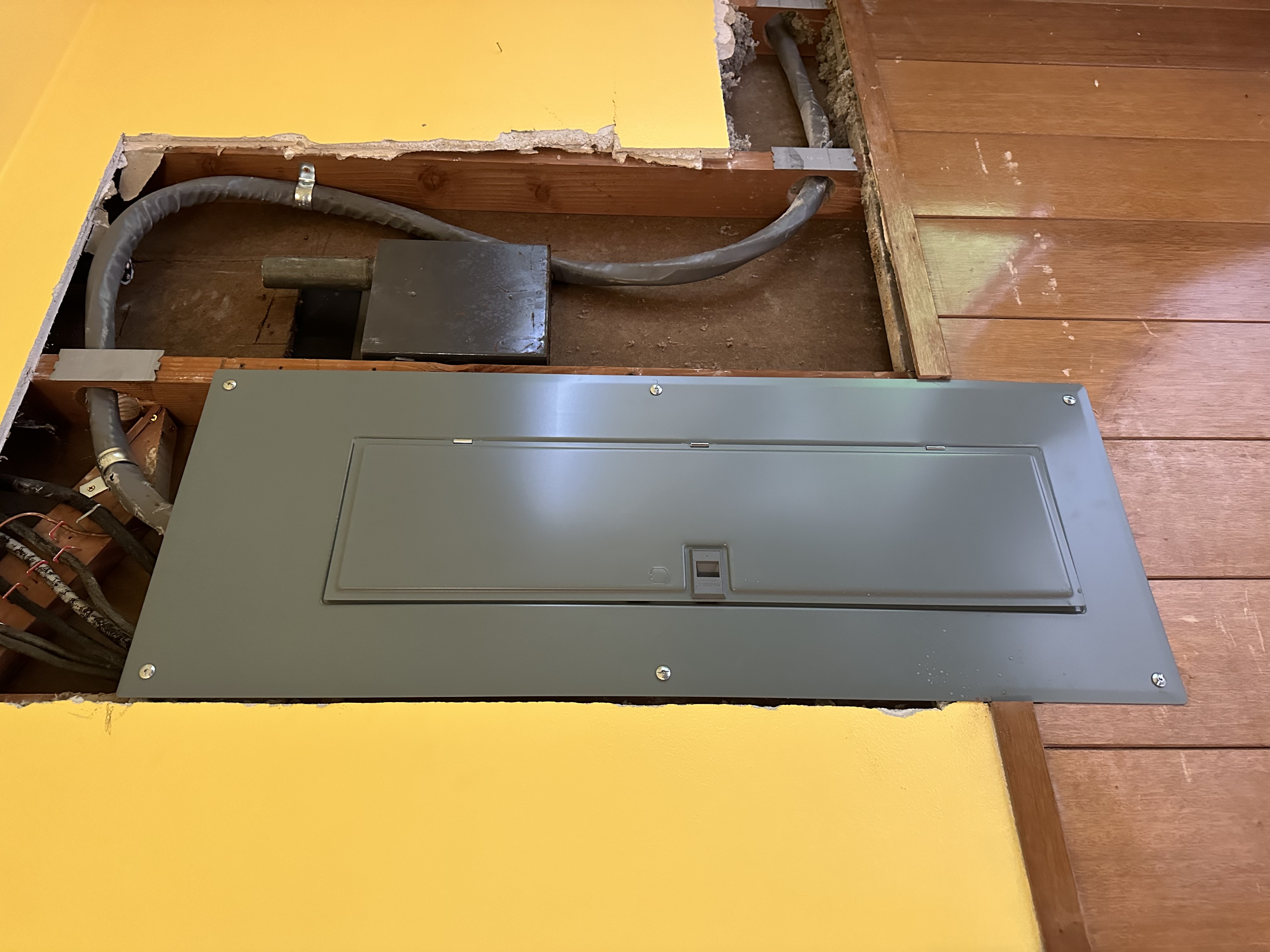 Subpanel and conduit rough-in during residential remodel framing.