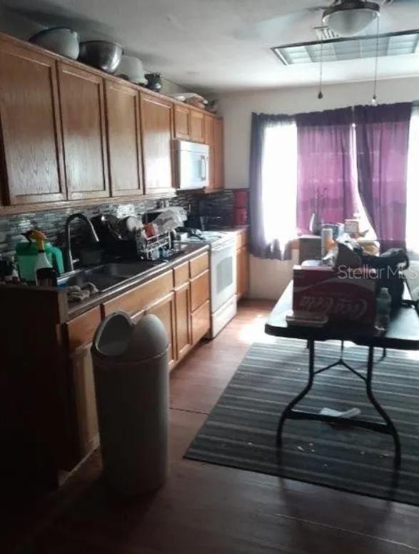 Kitchen before renovation with cluttered counters and sticky surfaces