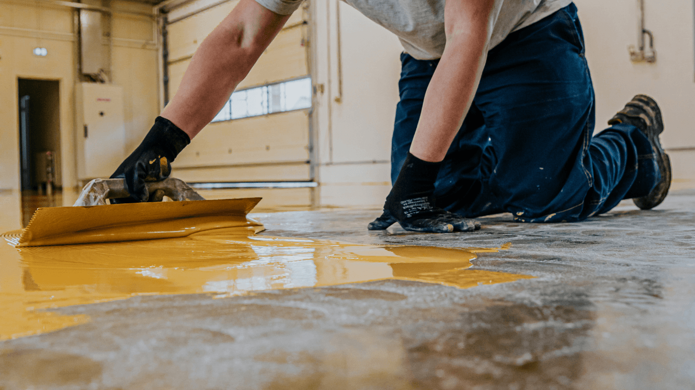Worker applying a new epoxy floor coating during an epoxy flooring installation in Glendale, AZ