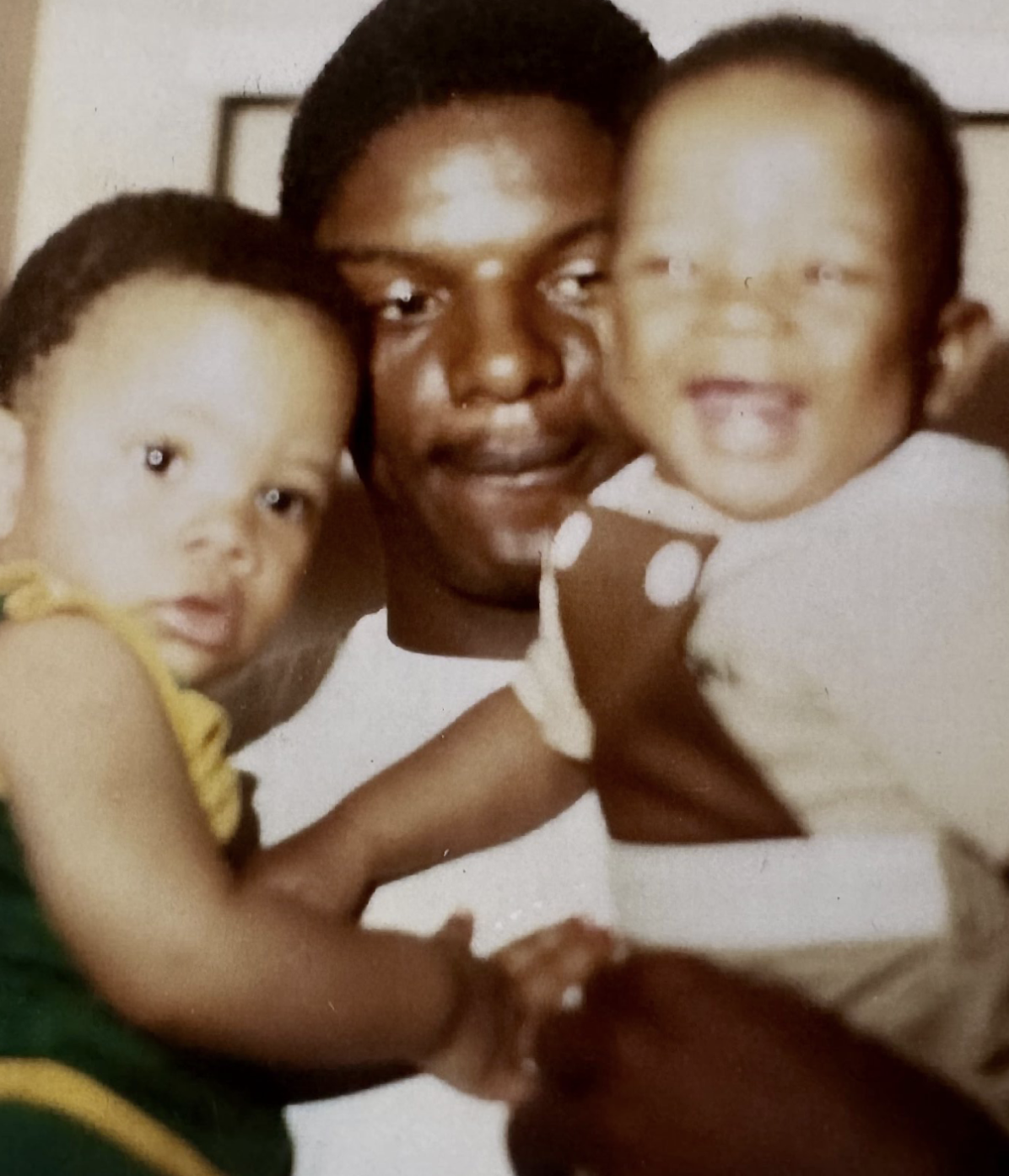 Vintage photograph of a man with two young children, one in yellow and one in white