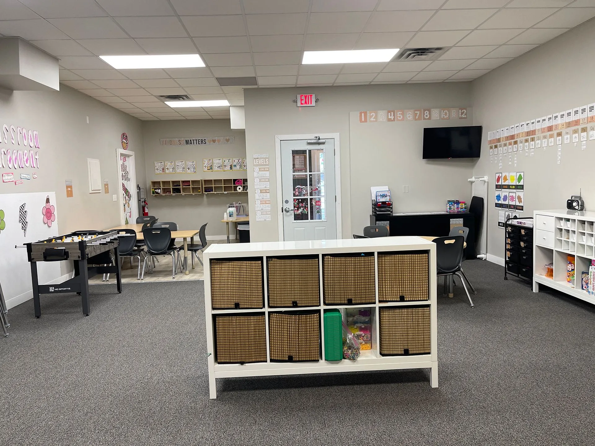 School-age classroom with foosball table, study tables, and organized storage cubbies