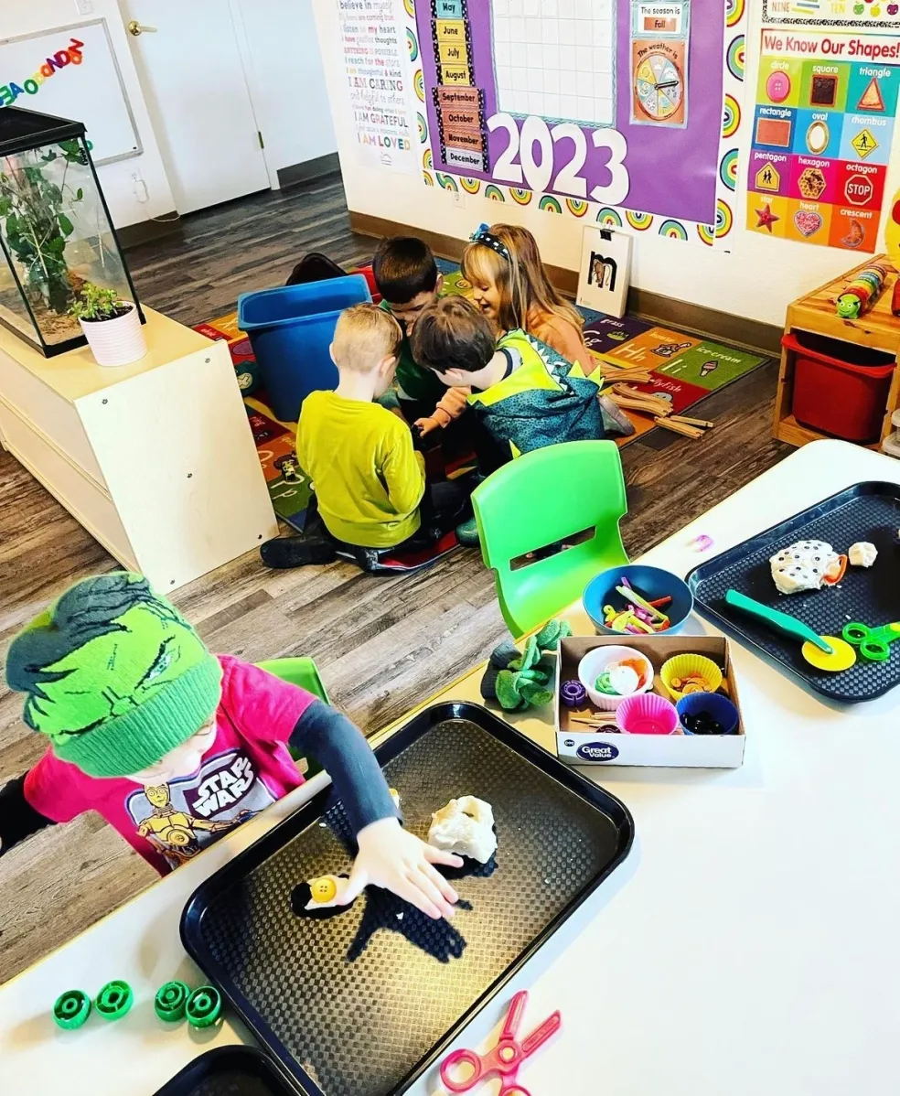 Children engaged in hands-on playdough shaping, counting, and small-group learning