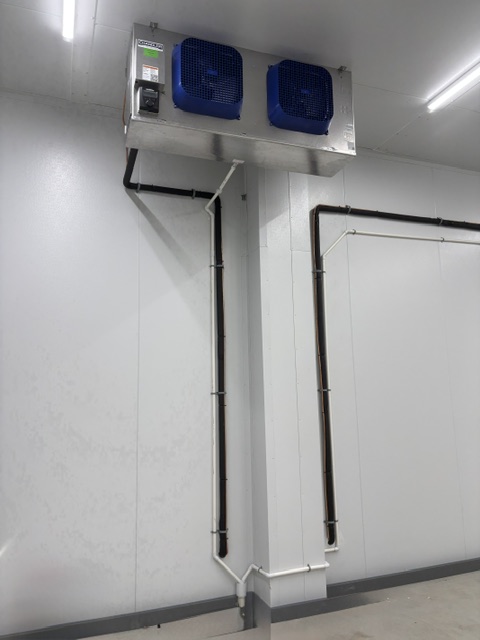 Refrigeration piping and evaporator unit inside commercial walk-in cooler