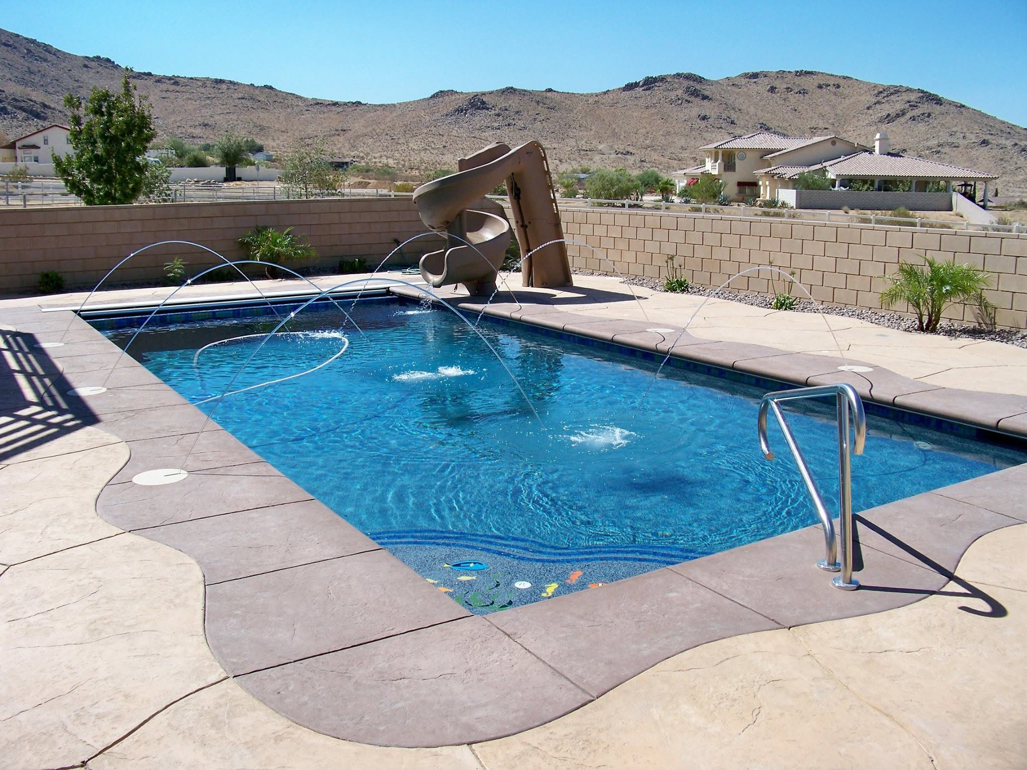 Backyard pool with fountain jets and slide in Ridgecrest, CA cared for by Connor Jaeger Pool Service