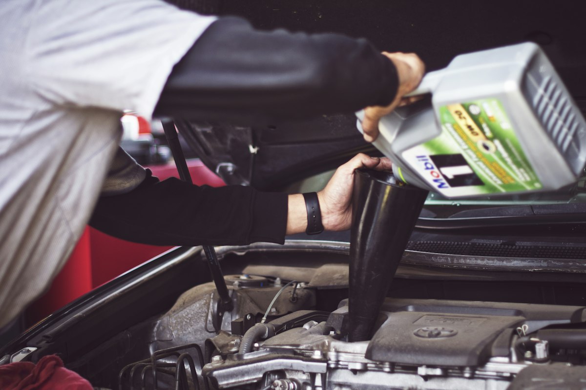 Technician checking engine oil level