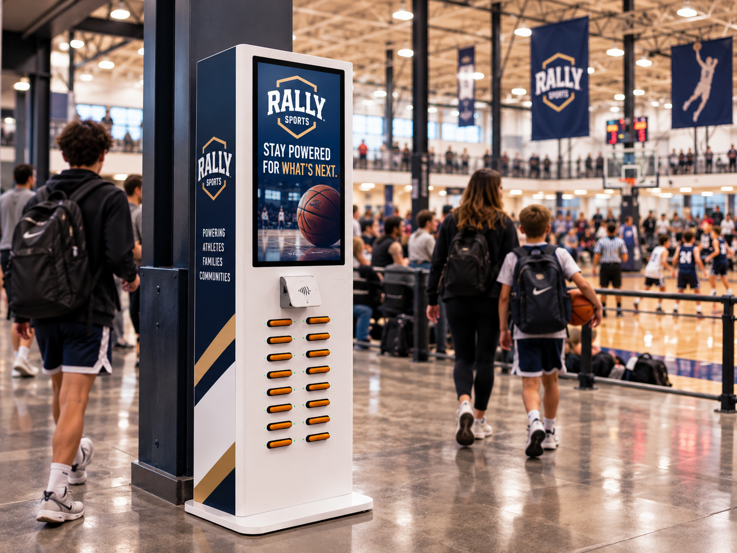 A tall RALLY SPORTS branded charging station in an active indoor sports tournament facility