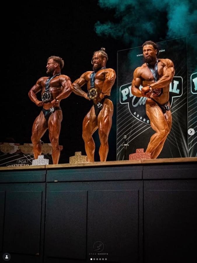 James Alabaster on stage in the PCA podium callout lineup with medal
