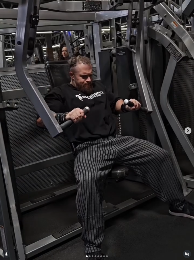 James Alabaster training chest press on Hammer Strength machine in Silverback apparel