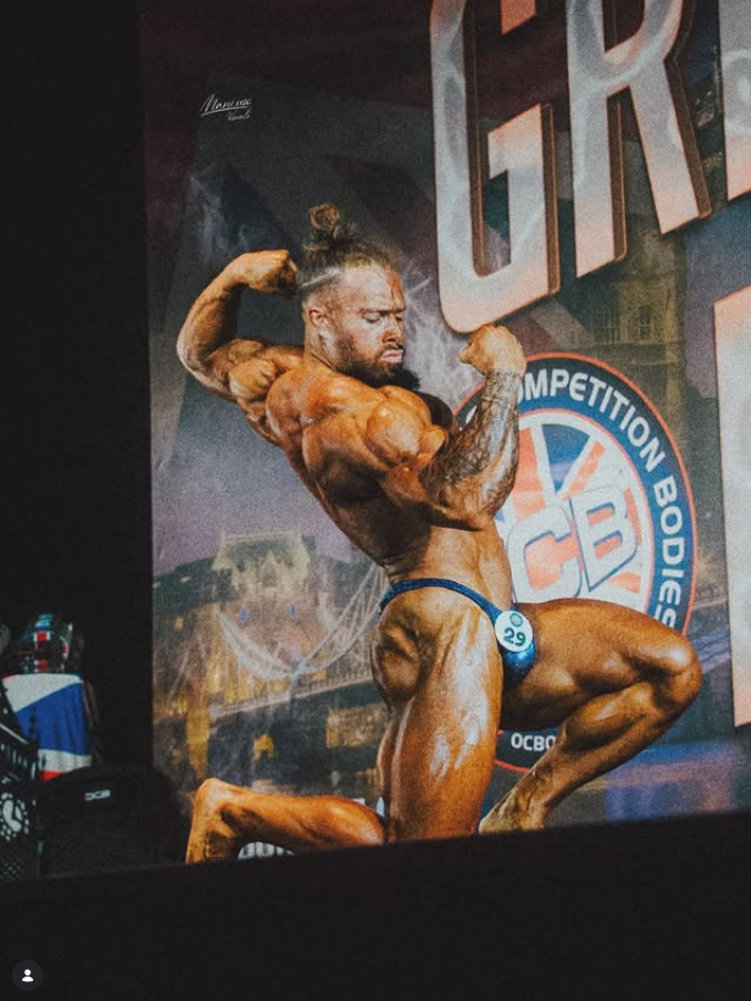 James Alabaster kneeling side pose at OCB competition