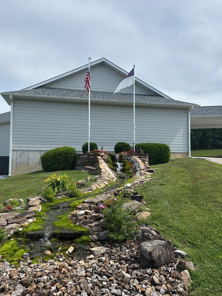 Landmark Baptist Church grounds and facility in Rolla, Missouri, showing the church building, flagpoles, waterfall, and stream
