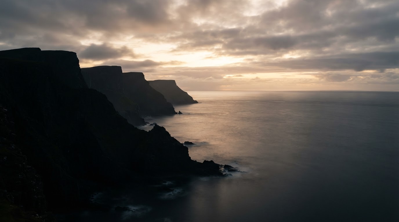 Dramatic coastal cliffs and ocean horizon at sunrise