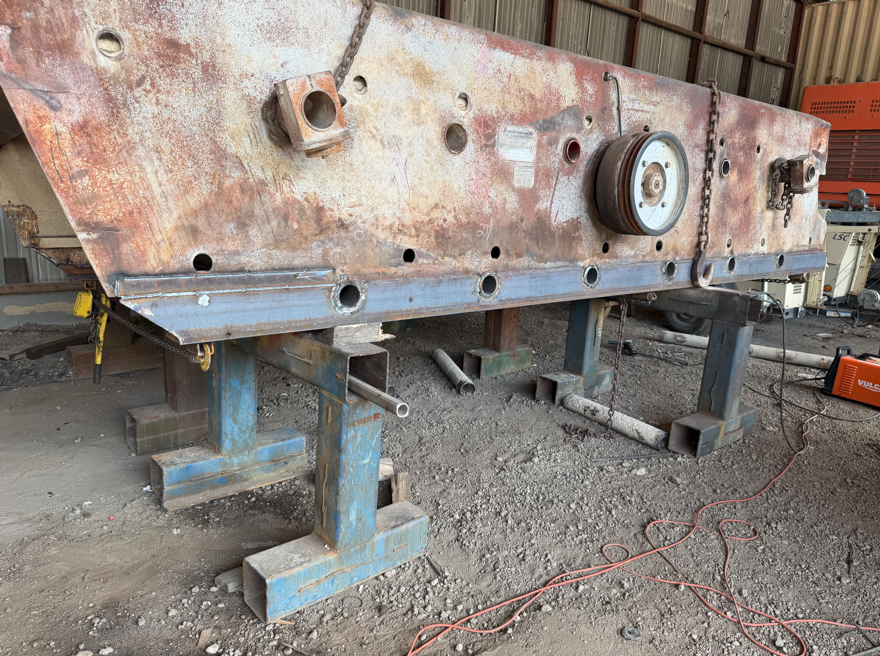 Industrial vibrating screen body supported on stands with a new flange bar welded along the lower edge