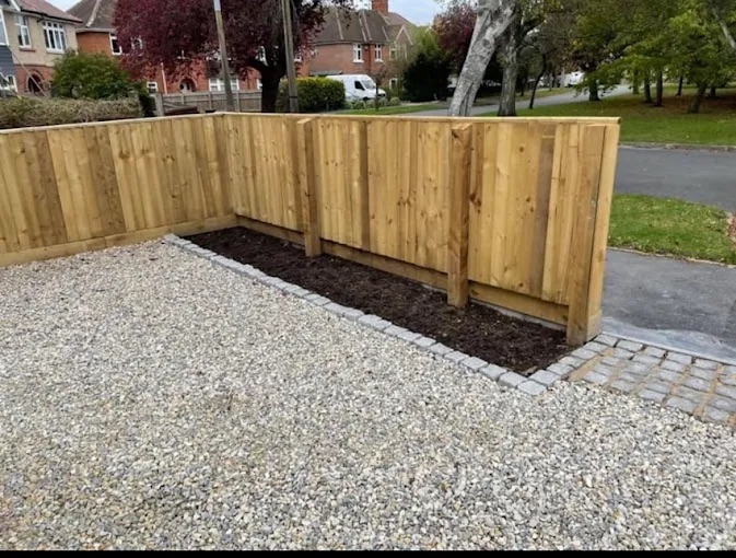 Gravel driveway installation with timber feather edge fencing and cobble sett border