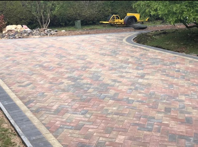 Sweeping multi-blend herringbone block paving driveway with curved charcoal perimeter edging