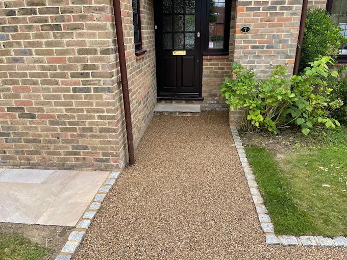 Golden resin bound front walkway and doorstep entrance with granite sett border