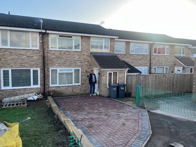 Finished red multi-blend block paving driveway with charcoal border and timber sleeper retaining wall