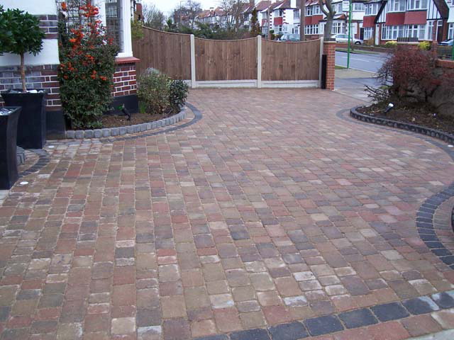 Multi-tone tumbled block paving with contrasting curved dark border