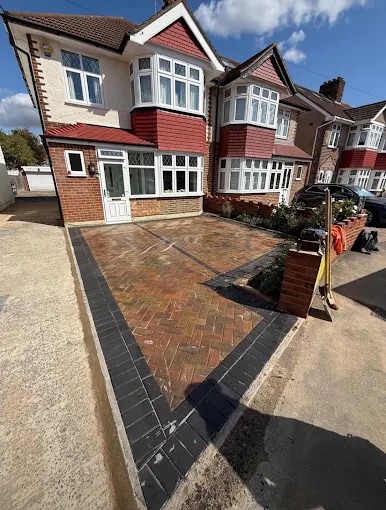 Residential front block paving driveway with multi-tone herringbone bricks and charcoal perimeter border