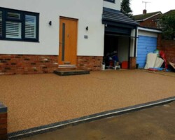 Smooth golden resin-bound driveway forecourt with linear drainage channel