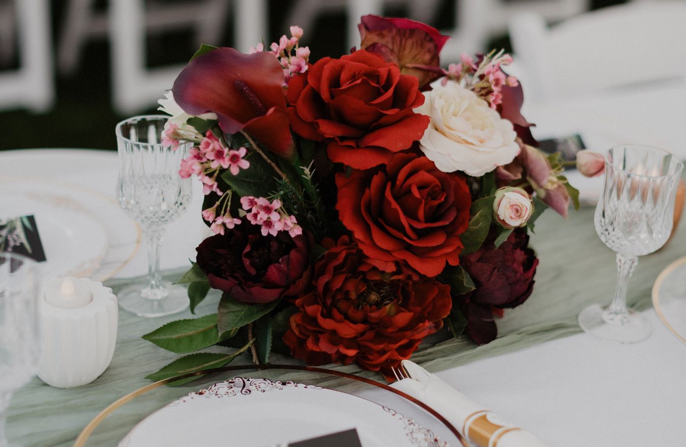 fresh red and burgundy rose centerpiece floral arrangement with candles for wedding table in Seattle