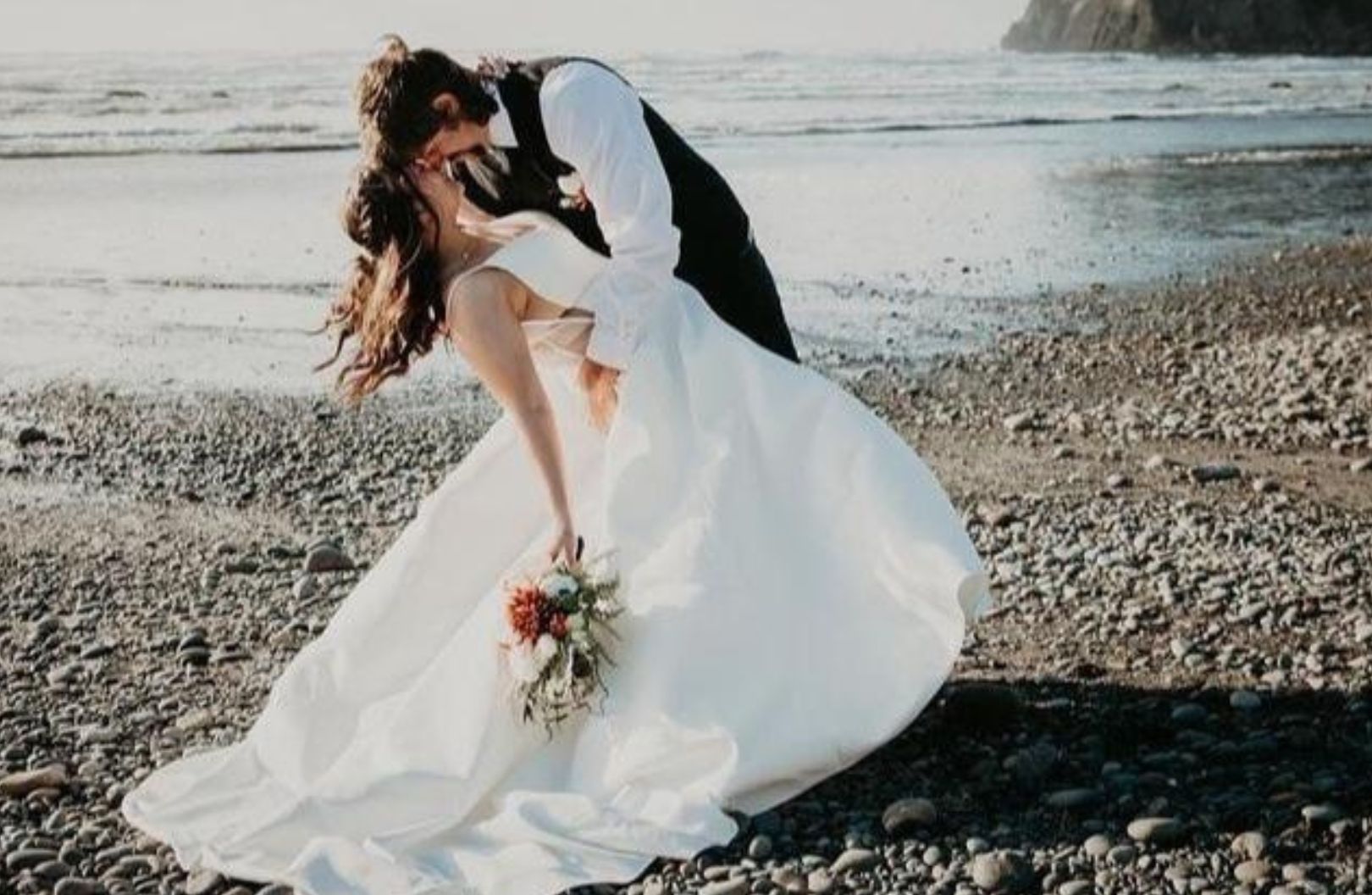 Bride holding custom wedding bouquet during beach wedding ceremony