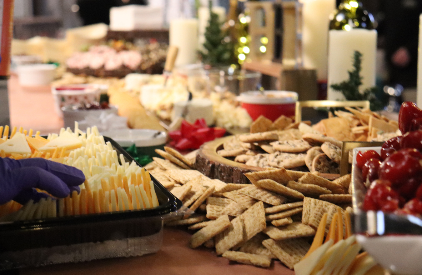 grand celebration grazing table with artisan cheeses, crackers, candles, and fresh berries