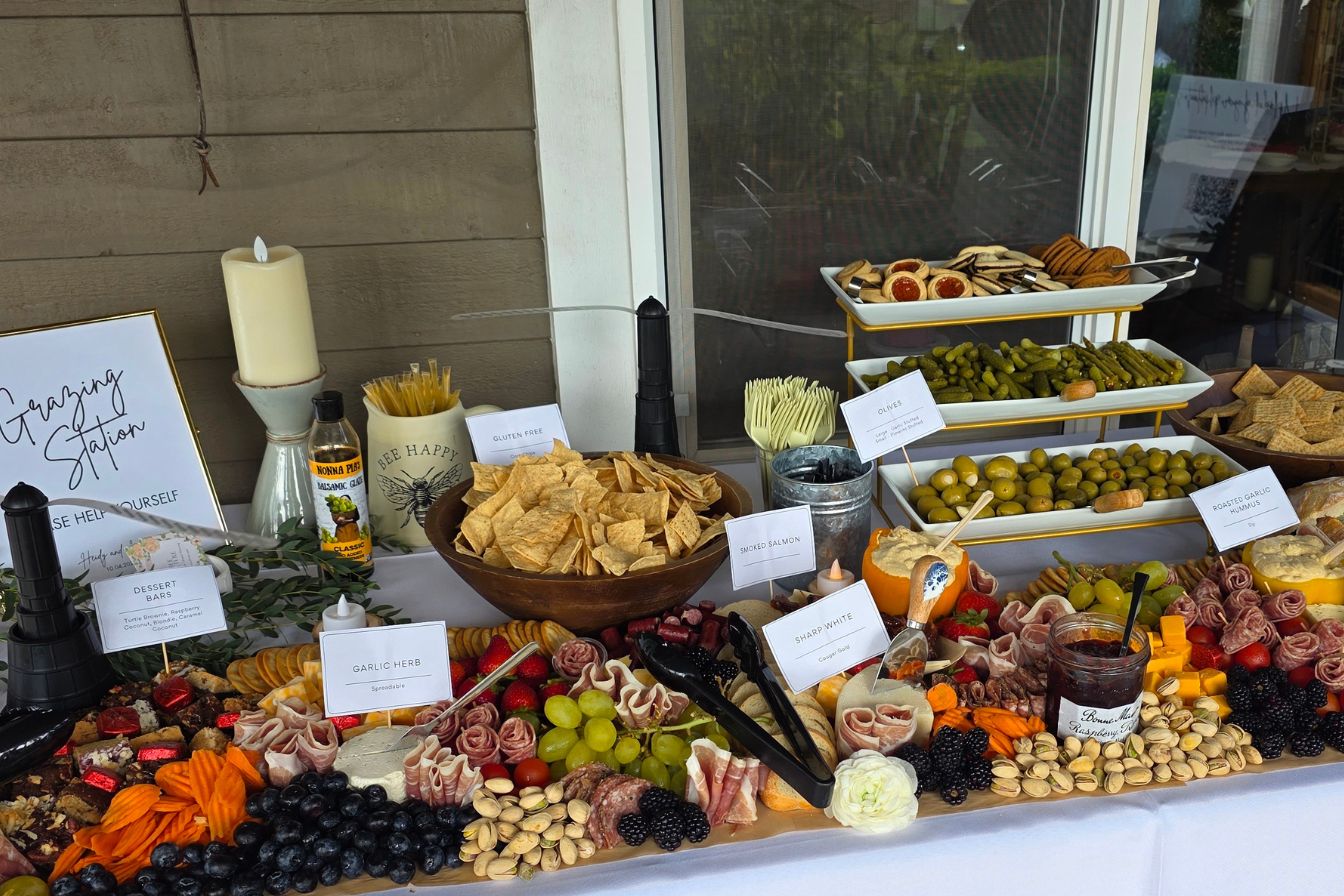 luxury charcuterie grazing table catering display with artisan cheeses cured meats fresh fruits and custom labels for wedding reception