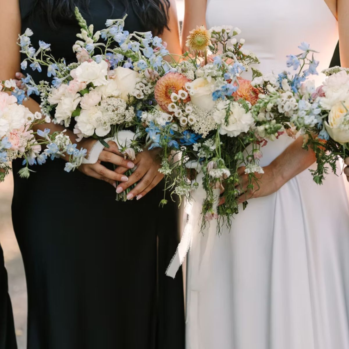 Custom bridal bouquets with white roses blue delphiniums peach flowers and greenery for wedding floral arrangements in Kitsap County
